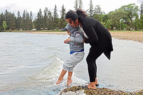 Charlot Asejo dips her son Charles’ feet in the cool water of Clear Lake at the beach in Wasagaming during a family trip to Riding Mountain National Park on a very windy Wednesday afternoon. Four-year-old Charles has autism and loves water. See more photos on Page A5. (Tim Smith/The Brandon Sun)