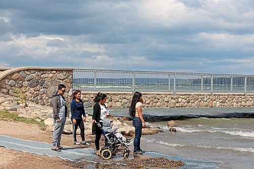 16082023
Alvin Asejo, his mother-in-law Estrella Noble, wife Charlot Asejo and children Charles, four, and Sofia, fourteen, from Souris, look out over the waves on Clear Lake at the beach in Wasagaming on a very windy Wednesday afternoon. 
(Tim Smith/The Brandon Sun)