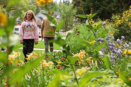 16082023
Chloe Stoesz, 11, of Steinbach, checks out the flowers in one of the colourful gardens in Wasagaming during a family trip on Wednesday. (Tim Smith/The Brandon Sun)