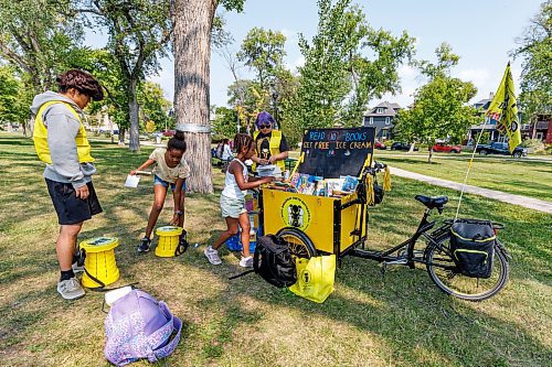 MIKE DEAL / WINNIPEG FREE PRESS
The West Broadway Youth Outreach Book Bike made a stop in Vimy Ridge Park Thursday. The Book Bike incentivizes reading by getting children to read ten books to a WBYO staff member in return for a free ice cream.
(From left) Takuto Yokoyama an exchange student working with WBYO listens to Rufta, 11, read a book while Errata, 8, reads to Vex Young a WBYO staff member in Vimy Ridge Park Thursday. 
230817 - Thursday, August 17, 2023.