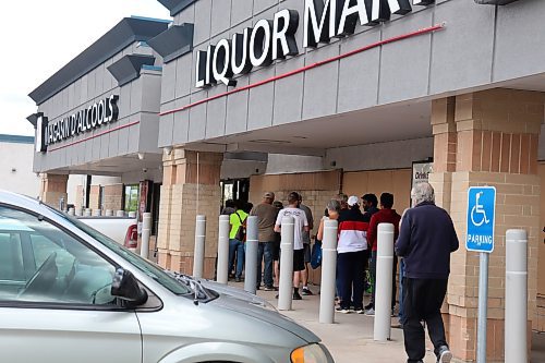 A line of nearly 100 people gathered outside the St. Vital Square Liquor Mart at 827 Dakota St. Saturday. (Tyler Searle / Winnipeg Free Press)