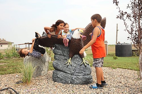 18082023
Kids play on a statue at the Birdtail Sioux First Nation Healing Garden while waiting for a free pair of Under Armour shoes on Friday. Tr&#xe9;chelle Bunn, founder of the Reconciliation Run, organized the donation of 213 pairs of shoes from Under Armour and helped hand out the shoes with other volunteers. Community members could also sign up for the 2023 Reconciliation Run at the event.   (Tim Smith/The Brandon Sun)