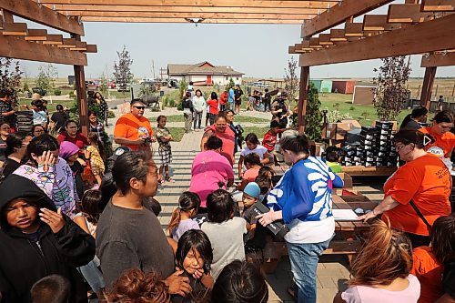 18082023
Kids crowd together to get free pairs of Under Armour shoes at the Birdtail Sioux First Nation Healing Garden on Friday. Tr&#xe9;chelle Bunn, founder of the Reconciliation Run, organized the donation of 213 pairs of shoes from Under Armour for children at Birdtail and helped hand out the shoes with other volunteers. Community members could also sign up for the 2023 Reconciliation Run at the event.   (Tim Smith/The Brandon Sun)