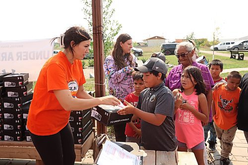 18082023
Tr&#xe9;chelle Bunn, founder of the Reconciliation Run, hands out pairs of Under Armour shoes to children at the Birdtail Sioux First Nation Healing Garden on Friday. Bunn organized the donation of 213 pairs of shoes from Under Armour for children at Birdtail and helped hand out the shoes with other volunteers. Community members could also sign up for the 2023 Reconciliation Run at the event.   (Tim Smith/The Brandon Sun)