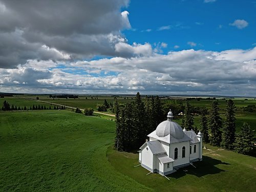 The sun shines through a break in fast moving clouds to illuminate the St. Nicholas Ukrainian Catholic Church in Keld, Manitoba, southwest of Dauphin, on a recent windy and rainy day. The church was built in 1919-20.  (Tim Smith/The Brandon Sun)