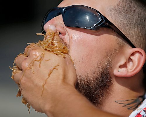 JOHN WOODS / WINNIPEG FREE PRESS
MacKenzie Falk competes in an eating contest of philippine pancit and bbq pork during Streat Feast at the Forks in Winnipeg, Sunday, August  20, 2023. 

Reporter: standup