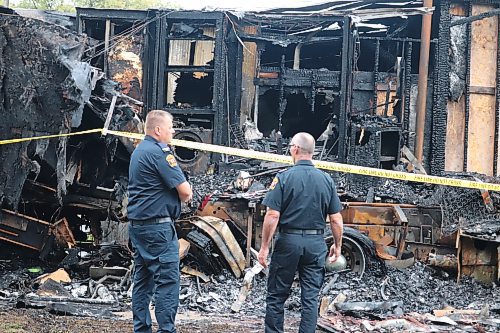 Brandon Fire and Emergency Services members Michael Lees (fire inspector) and Joe Szabo (fire prevention officer) attend Assiniboine Collision and Glass Monday morning to survey the damage. (Kyle Darbyson/The Brandon Sun)