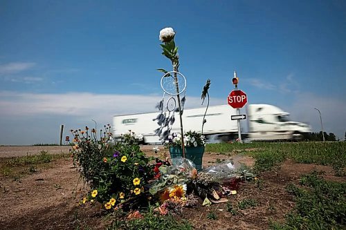 TIM SMITH / THE BRANDON SUN FILES

A semi trailer pass by flowers and other items placed at the intersection of the Trans Canada Highway and Highway 5 just north of Carberry as a memorial to the victims of the devastating collision between a semi trailer and a passenger bus carrying seniors from Dauphin to the Sand Hills Casino back in June. (File)