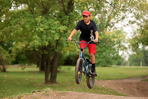 21082023
Ryan Houle sails over a jump at the bike tracks on 3rd Street in Brandon&#x2019;s south end while biking with friends on Monday. 
(Tim Smith/The Brandon Sun)