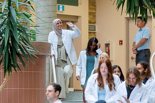 MIKE DEAL / WINNIPEG FREE PRESS
Fatima Saqib waves to family and friends after taking part in the White Coat Ceremony.
Family, friends and medical dignitaries gather in the Brodie Centre Atrium, Bannatyne Campus, 727 McDermot Avenue, for the University of Manitoba&#x2019;s Inaugural Day Exercises of the largest medical class in University of Manitoba history, the Class of 2027. The Max Rady College of Medicine will see 125 incoming medical students this coming year up from 110 students in recent years. During the event the new students take part in the White Coat Ceremony and recite the Physician&#x2019;s Pledge.
See Tessa Adamski story 
230823 - Wednesday, August 23, 2023.