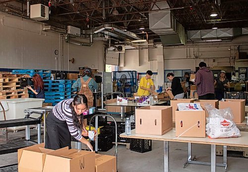 Mike Thiessen / Winnipeg Free Press 
Students pack boxes of food as part of the Winnipeg School Division Summer Hamper Program, which aims to support up to 800 families throughout July and August. For Tessa Adamski. 230824 &#x2013; Thursday, August 24, 2023