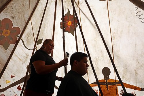 24082023
Dawson Bell of Sioux Valley Dakota Nation has his hair cut in a teepee by Luz Cifutes during Dakota Tiwahe Days at Grand Valley Park outside Brandon on Thursday. The family days began Tuesday and wrap up today with an Amazing Race style scavenger hunt. Some of the other events included horse riding, laser tag and a dance party.
(Tim Smith/The Brandon Sun)