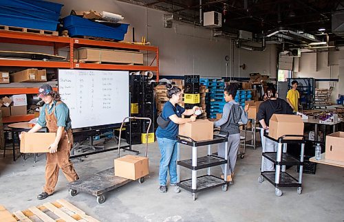 Mike Thiessen / Winnipeg Free Press 
Students pack boxes of food as part of the Winnipeg School Division Summer Hamper Program, which aims to support up to 800 families throughout July and August. For Tessa Adamski. 230824 &#x2013; Thursday, August 24, 2023