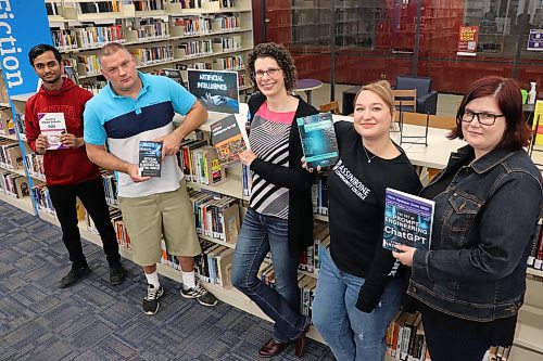 Members of the Assiniboine Community College library — Jenil Patel, Josh Seeland, Sharon Enns, KC Bateman and Shannon MacGregor — pose for a group photo on Thursday, showcasing the books they’ve cultivated for their new section on artificial intelligence. While utilizing AI tools for certain coursework is considered cheating under ACC’s recently modified Policy on Academic Integrity, it is still being allowed in specific circumstances to help enhance student learning. (Kyle Darbyson/The Brandon Sun)