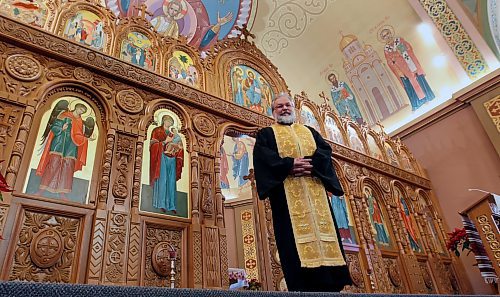 Rev. Michael Kwiatkowski poses for a photo alongside the iconostasis at the Holy Eucharist Church in January 2015. (Wayne Glowacki/Winnipeg Free Press)