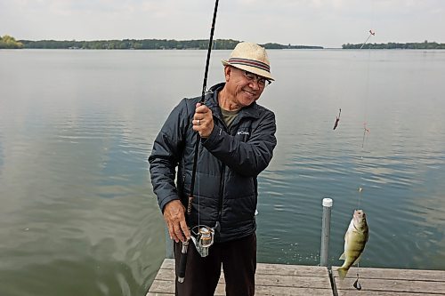 Bert Bautista catches a fish while fishing with friends from a dock on Killarney Lake on Monday. (Tim Smith/The Brandon Sun)