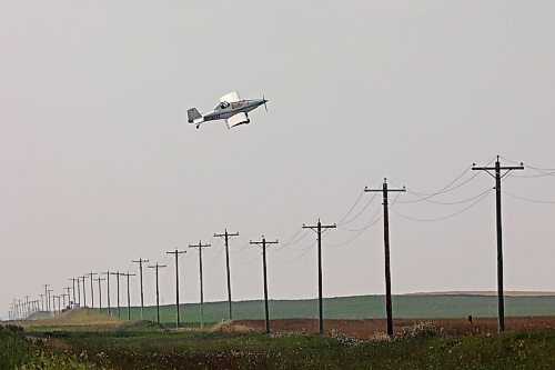 28082023
An aerial sprayer flies low over power lines while spraying a crop near Margaret, Manitoba on Monday afternoon. 
(Tim Smith/The Brandon Sun)