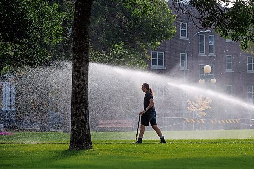 MIKE DEAL / WINNIPEG FREE PRESS
Standup
Mist from sprinklers on the lawn of the Manitoba Legislative building provide a halo around a pedestrian Tuesday morning. 
230829 - Tuesday, August 29, 2023.