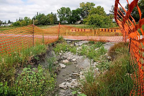 Mike Thiessen / Winnipeg Free Press 
A massive hole in the ground near the Sturgeon Creek pathway has yet to be repaired after appearing in June. The city hopes to develop a plan to fix it by mid-September. For Joyanne Pursaga. 230829 &#x2013; Tuesday, August 29, 2023