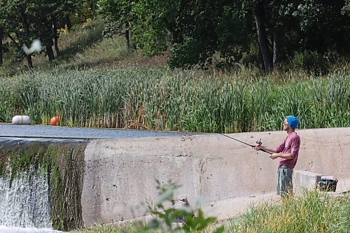 Brett Mallette from Brandon casts his line into river near the Souris Dam on a warm Wednesday afternoon. (Matt Goerzen/The Brandon Sun)