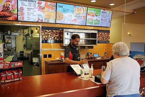 Royal Fork Foods and TacoTime co-founder Alpesh Patel serves a customer. (Abiola Odutola/The Brandon Sun)