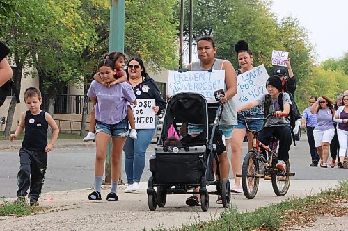 Holding a "Prevent overdose!" sign, Georgia Pelletier walks with her infant son and teenage daughter along Ninth Street during International Overdose Awareness Day activities in Brandon on Thursday afternoon. For a story on the event, turn to Page A3. (Matt Goerzen/The Brandon Sun)