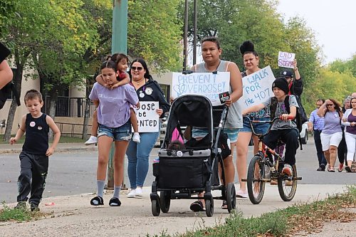 Holding a &quot;prevent overdose!&quot; sign, Georgia Pelletier walks with her infant son and teenage daughter along Ninth Street during International Overdose Awareness Day activities in Brandon on Thursday afternoon. (Matt Goerzen/The Brandon Sun)