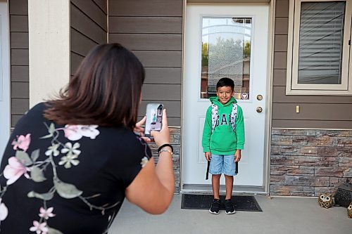 Viviana Rodriguez takes first-day-of-school photos of her son Bruno Zhou-Rodriguez on the front steps of their home before his first day of Grade 4 at Maryland Park School on Wednesday morning. For a story about students heading back to school, turn to Page A2. (Tim Smith/The Brandon Sun) 