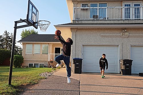 Mateo Landaverde-Cameron dunks the ball while playing basketball with his brother Nico before their first day back to school on Wednesday morning. Mateo is in Grade 8 and Nico is in Grade 4. (Tim Smith/The Brandon Sun) 