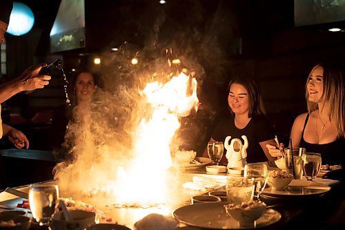 BROOK JONES / WINNIPEG FREE PRESS
Hailey Foster looks up at the flame with a big smile, while dining at Ichiban Japanese Steakhouse in Winnipeg, Man., Wednesday, Sept. 6, 2023. The Japanese steakhouse at 185 Carlton Street is celebrating its 50th anniversary. Pictured left to right: Ichiban chef Edwin Delacruz, Lakeview Hotels &amp; Resorts director of sales and marketing Carla Foster, Ichiban co-owner Keith Levit and Lakeview Hotels &amp; Resorts marketing coorindator Brookelynn Blanco and her cousin Hailey Foster.