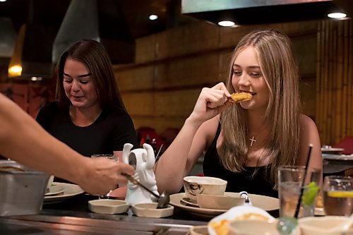 BROOK JONES / WINNIPEG FREE PRESS
Hailey Foster (right) enjoys a piece of shrimp, while dining at Ichiban Japanese Steakhouse in Winnipeg, Man., Wednesday, Sept. 6, 2023. The Japanese steakhouse at 185 Carlton Street is celebrating its 50th anniversary. Pictured left to right: Lakeview Hotels &amp; Resorts marketing coorindator Brookelynn Blanco and her cousin Hailey Foster.
