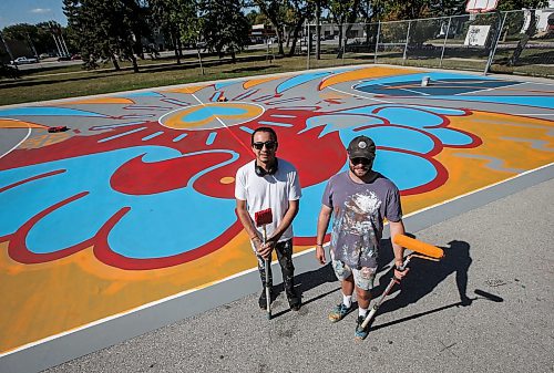 JOHN WOODS / WINNIPEG FREE PRESS
Artist Jordan Stranger, left, and Justin Lee, founder of the non-profit Buckets &amp; Borders, are photographed painting the court at St John&#x2019;s Park in Winnipeg Tuesday, September  12, 2023. Stranger designed the piece, Fly Like An Eagle, that is being painted on the court.  

Reporter: waldman