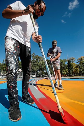 JOHN WOODS / WINNIPEG FREE PRESS
Artist Jordan Stranger, left, and Justin Lee, founder of the non-profit Buckets &amp; Borders, are photographed painting the court at St John&#x2019;s Park in Winnipeg Tuesday, September  12, 2023. Stranger designed the piece, Fly Like An Eagle, that is being painted on the court.  

Reporter: waldman