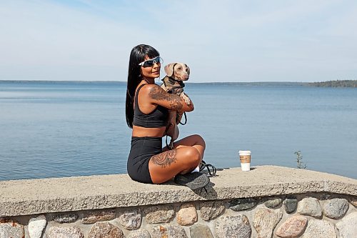 13092023
Patricia Silva sits with Carl, a dachshund, to have photos taken by Cait Bousfield (not shown) on the pier in Wasagaming on a warm Wednesday. 
(Tim Smith/The Brandon Sun)