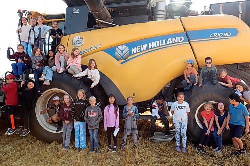 Students from Hamiota Elementary School pose for photos in front of a combine while learning about farming during the third annual Acres for Hamiota harvest on Thursday. Acres for Hamiota raises money for community projects and organizations. This year, 80 acres of wheat were seeded for the initiative and volunteers helped throughout the growing season from seeding to harvest. Donations from community members and local agriculture, seed and chemical companies helped cover the costs of growing the crop. Some of the profits from the initiative have gone toward the local golf course, the minor ball park, AED machines throughout the community and to the Hamiota Fire Department. Overnight rain meant harvesting the wheat had to be postponed, but community members and students still came together for a barbecue lunch. More photos on Page A4. (Tim Smith/The Brandon Sun)