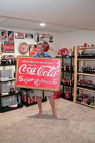 BROOK JONES / WINNIPEG FREE PRESS
Winnipegger Morris Glimcher, who was the executive director of the Manitoba High Schools Athletic Association from 1975 to 2016, is all smiles as he shows off his Coca-Cola collection of bottles and memorabilia in his rec room at his home in Winnipeg, Man., Wednesday, Sept. 13, 2023. Glimcher has been collecting Coca-Cola memorabilia for 20 years.