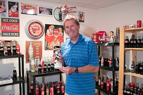 BROOK JONES / WINNIPEG FREE PRESS
Winnipegger Morris Glimcher, who was the executive director of the Manitoba High Schools Athletic Association from 1975 to 2016, is all smiles as he shows off his Coca-Cola collection of bottles and memorabilia in his rec room at his home in Winnipeg, Man., Wednesday, Sept. 13, 2023. Gliomcher is pictured holding a Wayne Gretzky - Athlete of the Decade - Coca-Cola water bottle from 1991. 