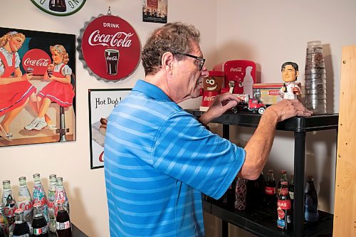 BROOK JONES / WINNIPEG FREE PRESS
Winnipegger Morris Glimcher, who was the executive director of the Manitoba High Schools Athletic Association from 1975 to 2016, shows off his Coca-Cola collection of bottles and collectibles in his rec room at his home in Winnipeg, Man., Wednesday, Sept. 13, 2023. Glimcher is pictured organizing some of his Coca-Cola memorabilia , which he has been collecting for 20 years. 