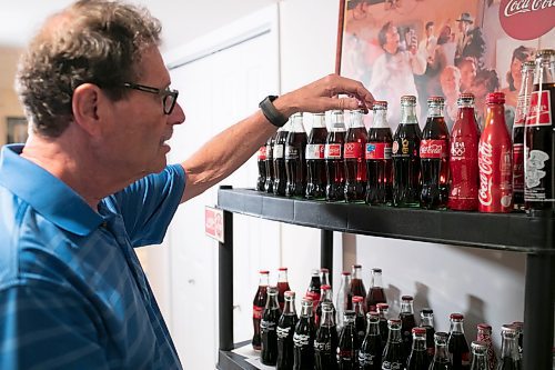 BROOK JONES / WINNIPEG FREE PRESS
Winnipegger Morris Glimcher, who was the executive director of the Manitoba High Schools Athletic Association from 1975 to 2016, shows off his Coca-Cola collection of bottles and memorabilia in his rec room at his home in Winnipeg, Man., Wednesday, Sept. 13, 2023. Glimcher is pictured organizing some of his unopened Coca-Cola bottles from varous Winter and Summer Olympic Games, such as Lake Placid (1980), Los Angeles (1984), Barcelona (1992), Atlanta (1996) and Salt Lake City (2002).