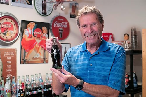 BROOK JONES / WINNIPEG FREE PRESS
Winnipegger Morris Glimcher, who was the executive director of the Manitoba High Schools Athletic Association from 1975 to 2016, shows off his Coca-Cola collection of bottles and memorabilia in his rec room at his home in Winnipeg, Man., Wednesday, Sept. 13, 2023. Glimcher is pictured holding an unopened Coca-Cola bottle from Japan. Glimcher has unopened Coca-Cola bottles from counrties around the world, such as Japan, China, Isreal, Bulgaria and Ethiopia. The Coca-Cola Company was founded in 1896 in Atlanta, Ga., and is sold in more than 200 countries worldwide.