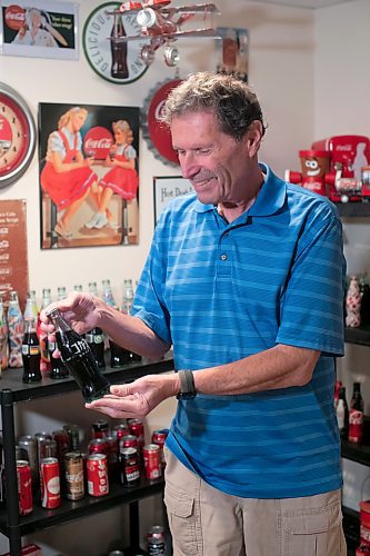 BROOK JONES / WINNIPEG FREE PRESS
Winnipegger Morris Glimcher, who was the executive director of the Manitoba High Schools Athletic Association from 1975 to 2016, shows off his Coca-Cola collection of bottles and memorabilia in his rec room at his home in Winnipeg, Man., Wednesday, Sept. 13, 2023. Glimcher is pictured looking at an unopened Coca-Cola bottle from Japan. Glimcher has unopened Coca-Cola bottles from counrties around the world, such as Japan, China, Isreal, Bulgaria and Ethiopia. The Coca-Cola Company was founded in 1896 in Atlanta, Ga., and is sold in more than 200 countries worldwide.