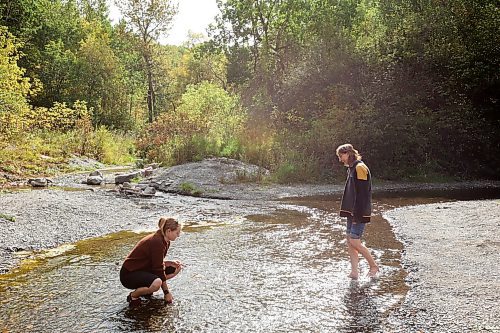 14092023
Kate Black of Brandon and her grandmother Janis Dutko of the Polonia area cool their feet in the shale-bed creek at Big Valley Park in the RM of Rosedale on a warm and sunny Wednesday. 
(Tim Smith/The Brandon Sun)