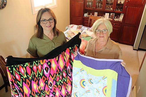Project Linus Westman members Trish Parobec and Bonnie Coombs showcase some of blankets they've collected at Parobec's Brandon home on Aug. 8. The mission statement of Project Linus, which has 45 chapters across Canada, is to provide comfort to children through the creation and distribution of these handmade blankets. (Kyle Darbyson/The Brandon Sun)