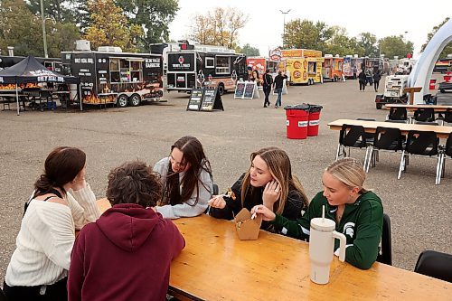 15092023
Friends (L-R) Jessie Weger, Curtis Splett, Shael Taylor, Olivia Wiebe and Gabi Wagner enjoy some food truck grub together during the opening day of Food Truck Warz 2023 at the Keystone Centre grounds on Friday. The food truck event and midway run until Sunday.
(Tim Smith/The Brandon Sun)