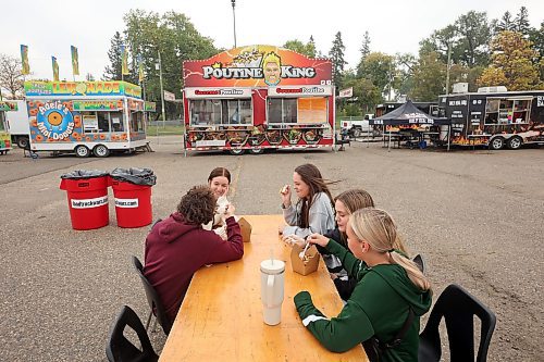 15092023
Friends (L-R) Curtis Splett, Jessie Weger, Shael Taylor, Olivia Wiebe and Gabi Wagner enjoy some food truck grub together during the opening day of Food Truck Warz 2023 at the Keystone Centre grounds on Friday. The food truck event and midway run until Sunday.
(Tim Smith/The Brandon Sun)