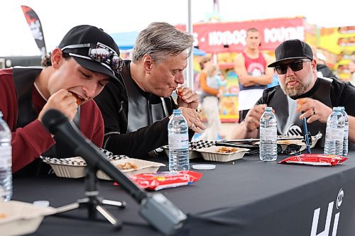 Former Brandon Wheat King and Florida Panthers defenceman Colby Robak chows down on some spicy wings between Sobeys franchise owner Ryan Hackett and Westman Communication Group president Bud Keys during Saturday’s hot wing eating contest at the Keystone Centre grounds. (Kyle Darbyson/The Brandon Sun)