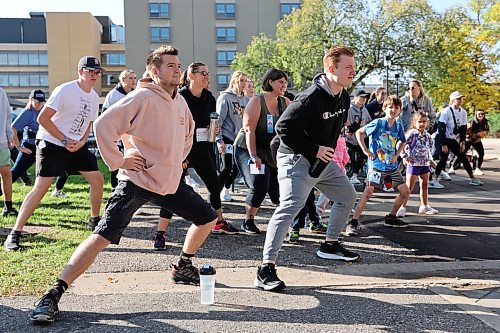 Participants of the 2023 Terry Fox Run take part in a group warm-up on Sunday morning before departing from Brandon University. (Kyle Darbyson/The Brandon Sun)