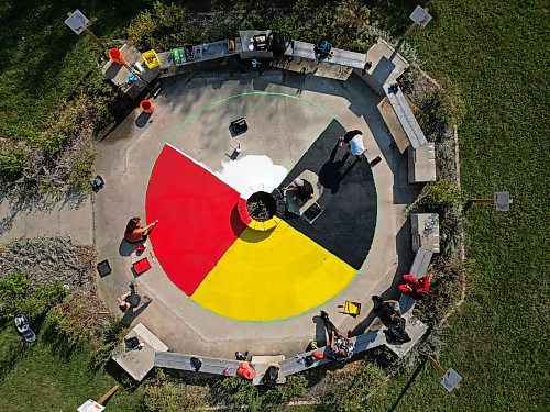 Volunteers organized through the Brandon Urban Aboriginal Peoples' Council and the BNRC Blue Door Project’s Ask Auntie program paint a medicine wheel at the All Nations Sharing Circle at the Riverbank Discovery Centre on Tuesday for upcoming Brandon Truth and Reconciliation Week events. (Tim Smith/The Brandon Sun)