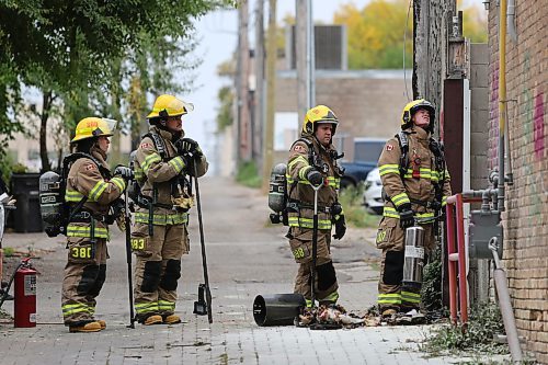 Brandon firefighters look at the remains of a burned wooden frame on the south end brick wall of the Laplont Block on Wednesday afternoon in downtown Brandon. Emergency crews, including Brandon police and fire, attended the scene of a garbage fire that appeared to have spread to a back gate of the property. (Matt Goerzen/The Brandon Sun)