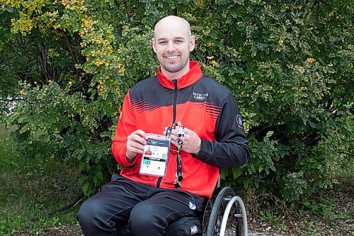 BROOK JONES / WINNIPEG FREE PRESS
Twenty-nine-year-old Lealand Muller, who represented Canada at the 2023 Invictus Games in D&#xfc;sseldorf, Germany from Sept. 9 to 16, is all smiles as he holds his athlete accreditation and various pins he collected at the game. Muller is pictured in his front yard at his home in Winnipeg, Man., Thursday, Sept. 21, 2023 and competed in hand cycle, discuss and wheelchair basketball. Canada will play host to the 2025 Invictus Game in Vancouver and Whistler. 